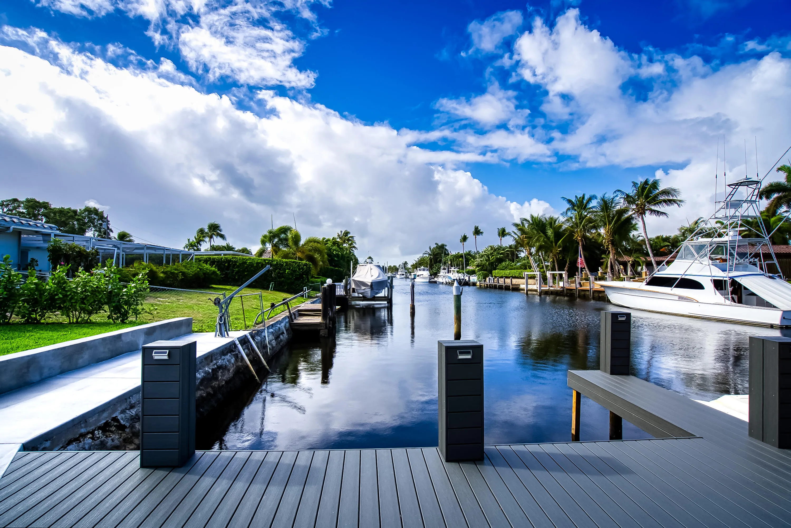 Waterfront property featuring a composite deck, two docking pilings, and direct canal access
