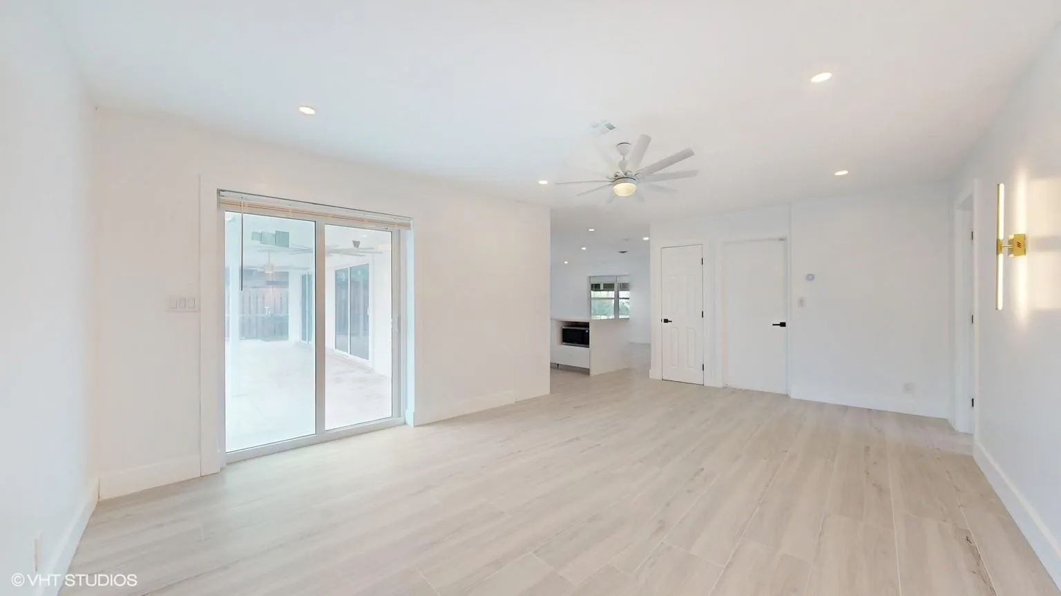 Large family room with large sliding glass doors that leads into the pool/patio area