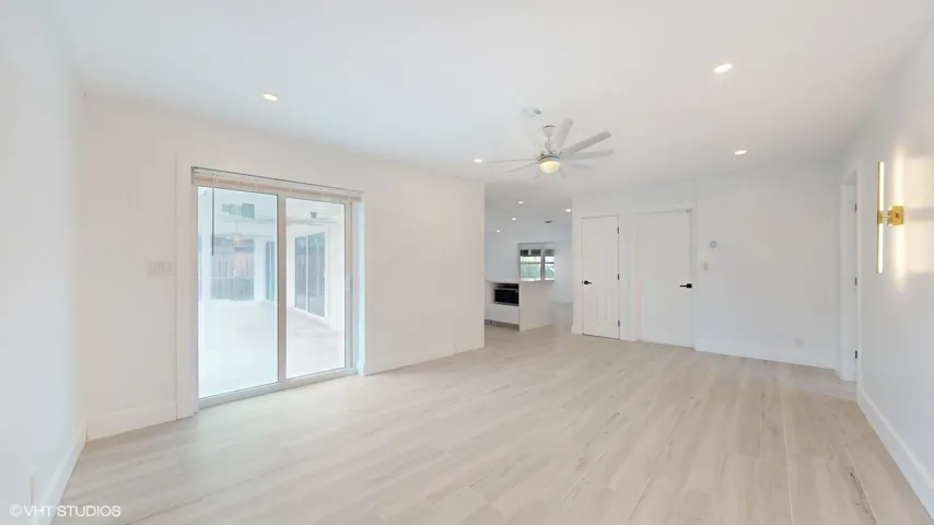 Large family room with large sliding glass doors that leads into the pool/patio area