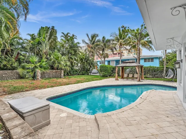 Freeform swimming pool surrounded by paver decking