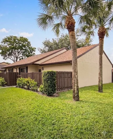Stucco exterior with a brown shingle roof