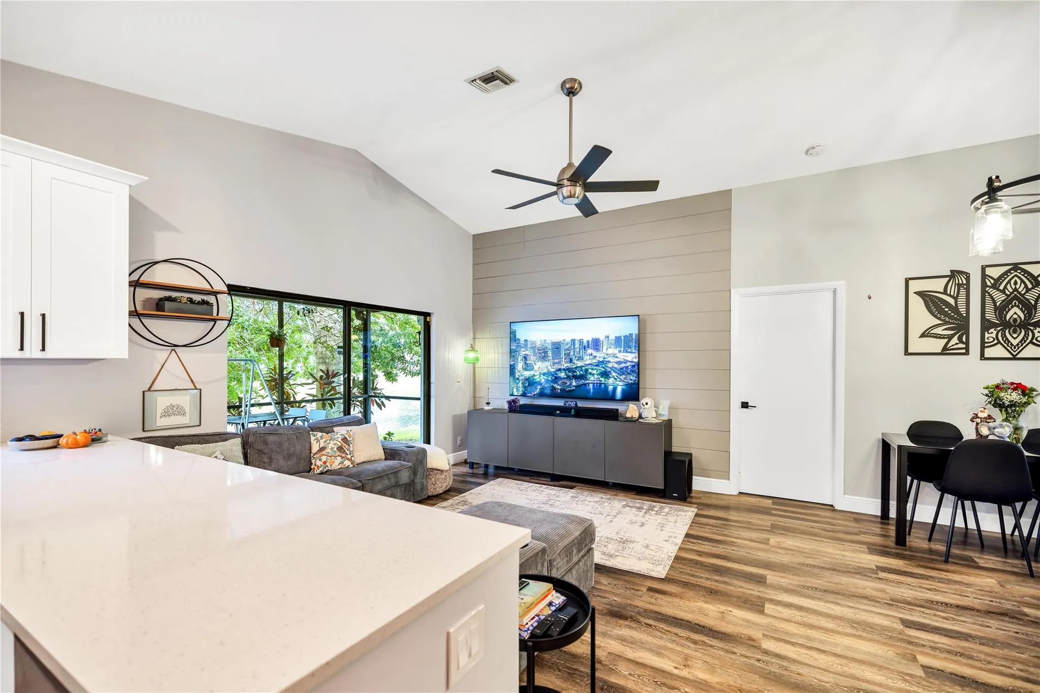 Living Area view from kitchen, with Slider to Patio. Kitchen counters are a diamond white quartz.