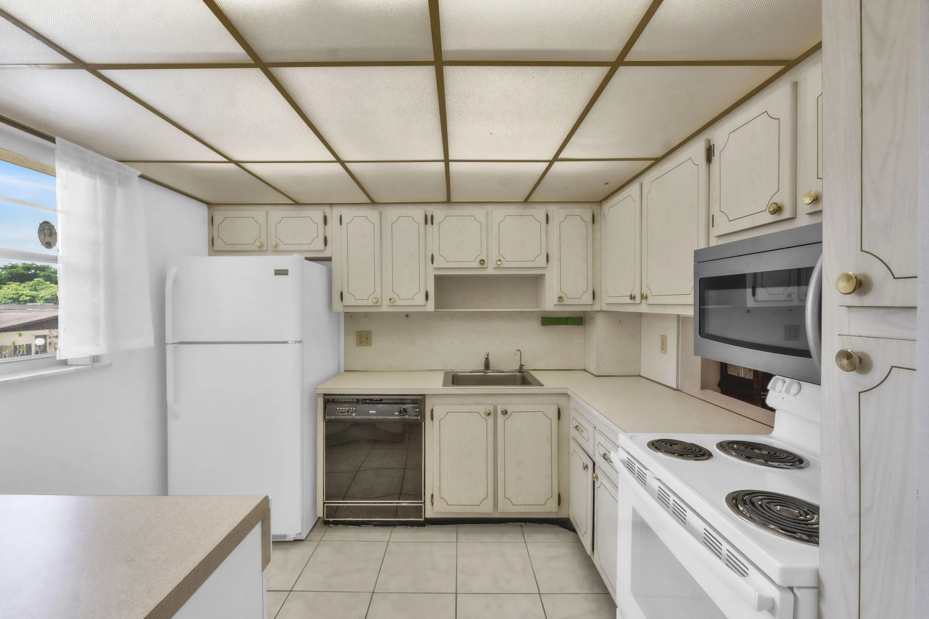 Kitchen featuring off-white cabinetry and tile flooring.