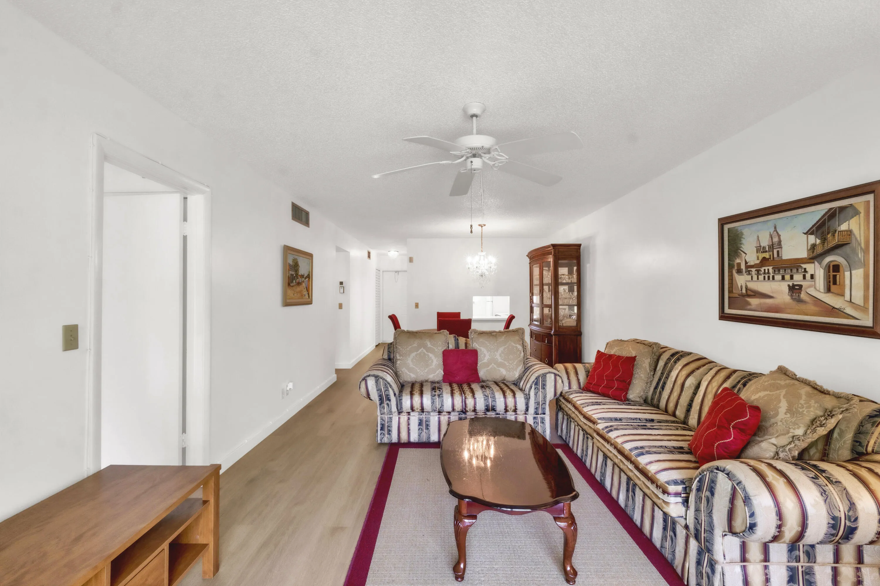 Spacious living area featuring luxury vinyl flooring and a ceiling fan.
