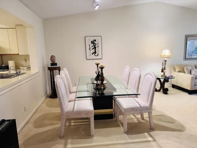 Vaulted ceiling dining area featuring a glass-top dining table