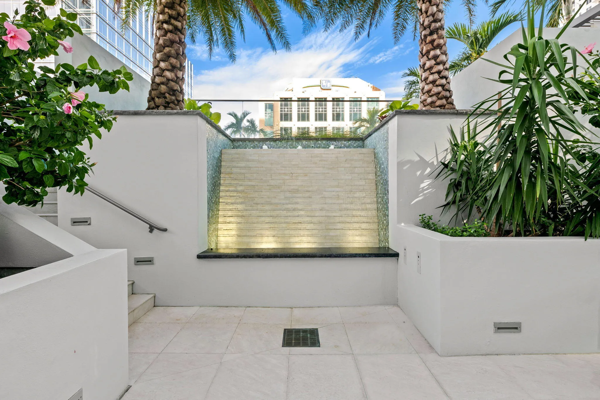 Outdoor water feature with integrated lighting, glass tile accents, and stacked stone texture