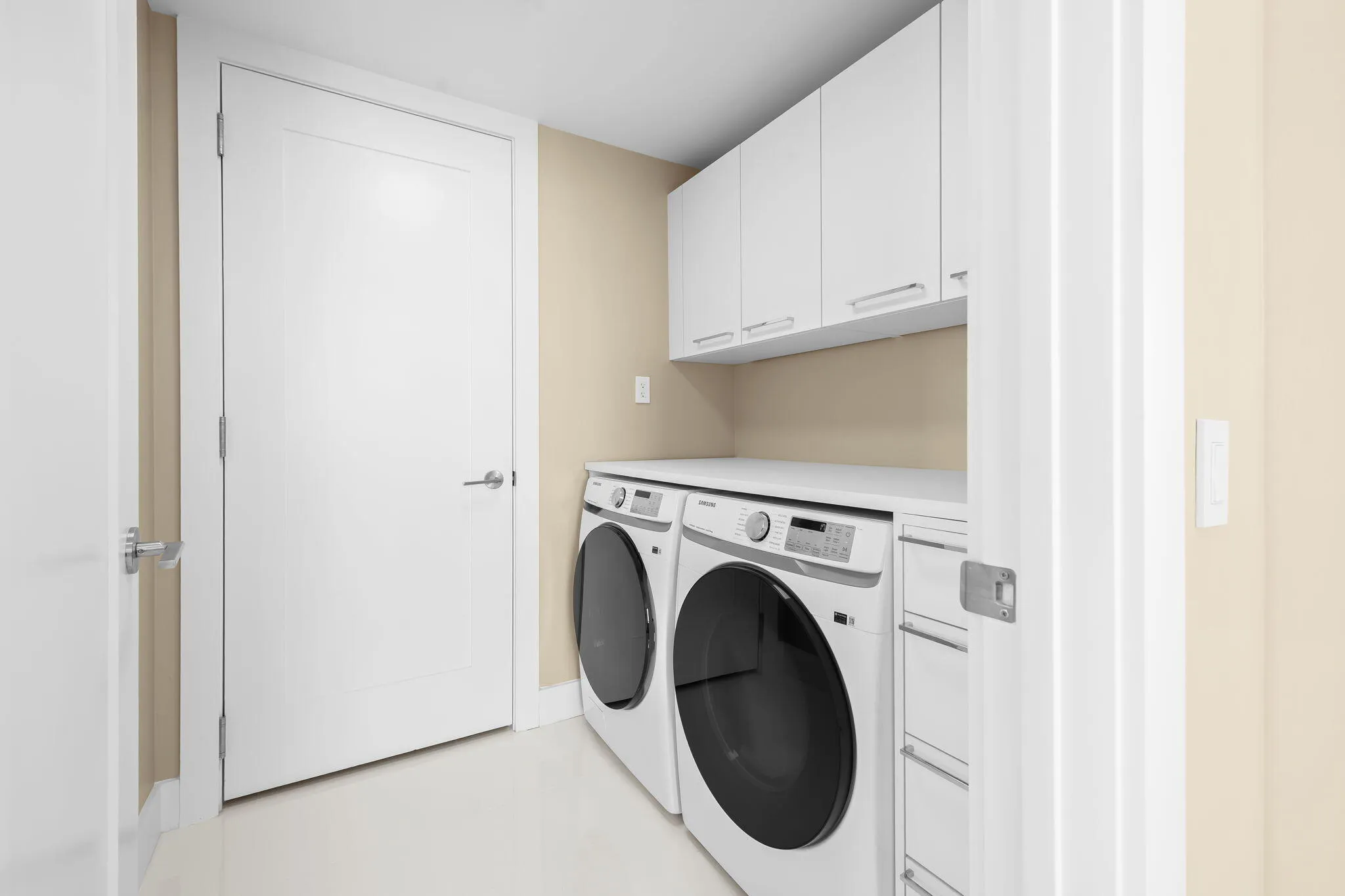 Dedicated laundry space featuring a side-by-side washer and dryer, white cabinetry, a white countertop, and light-toned wall paint