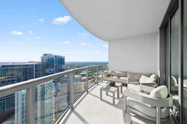 Expansive private balcony with a glass railing system and tile flooring