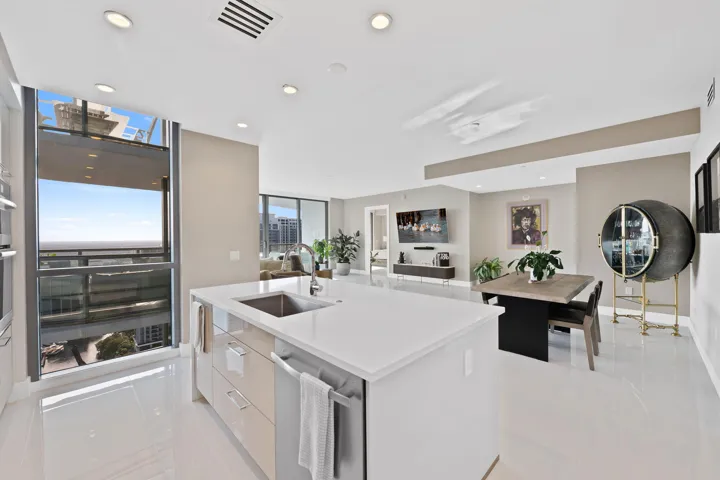 Modern kitchen island with an integrated sink, white countertop, and contemporary cabinetry
