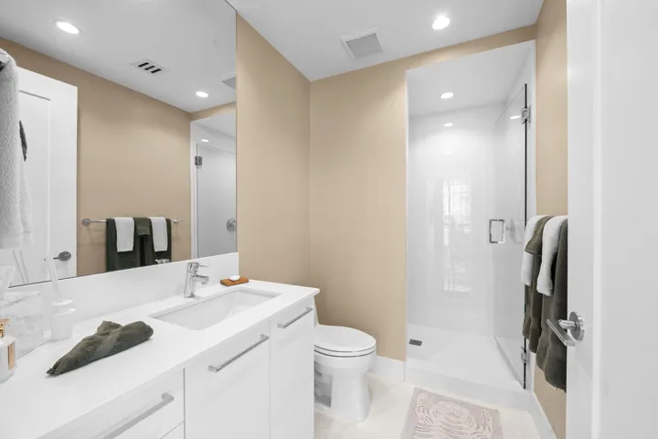 Contemporary bathroom featuring a single vanity with a white countertop and undermount sink, chrome faucet, and white cabinetry with bar pulls