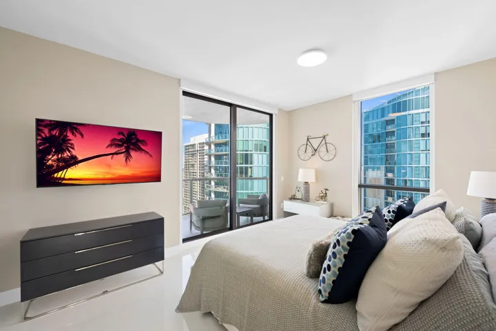 Expansive room featuring floor-to-ceiling windows, a full-height glass door, and cream-colored walls