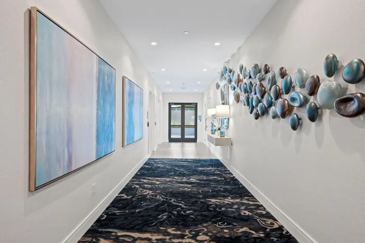 Long corridor featuring recessed lighting, a patterned area rug, and paneled walls