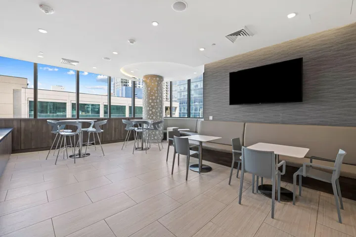 Expansive common area featuring large format tile flooring, extensive window line, recessed lighting, and a textured accent wall