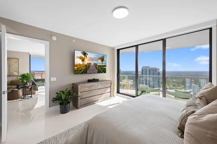 Expansive windows frame the cityscape, complemented by a private balcony with glass railings
