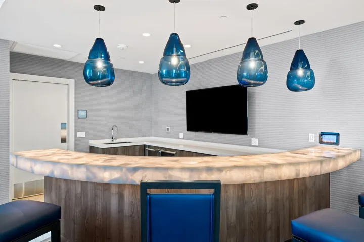Curved bar with a translucent countertop and wood-finish paneling