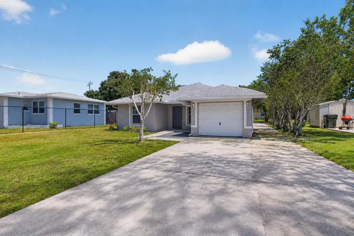 Lovely property featuring an oversized driveway, mature trees, and inviting curb appeal