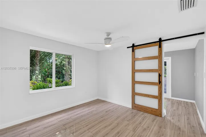 Second bedroom in Guest House with closet. Barn door provides access to a bonus room / office / 3rd bedroom