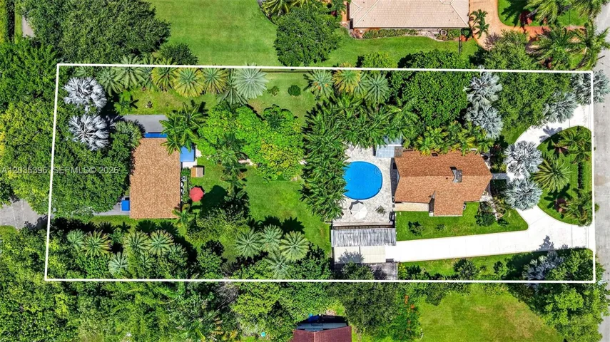 Large property with gorgeous grounds and mature trees, view of guest house on left and main house on right, separated by fence