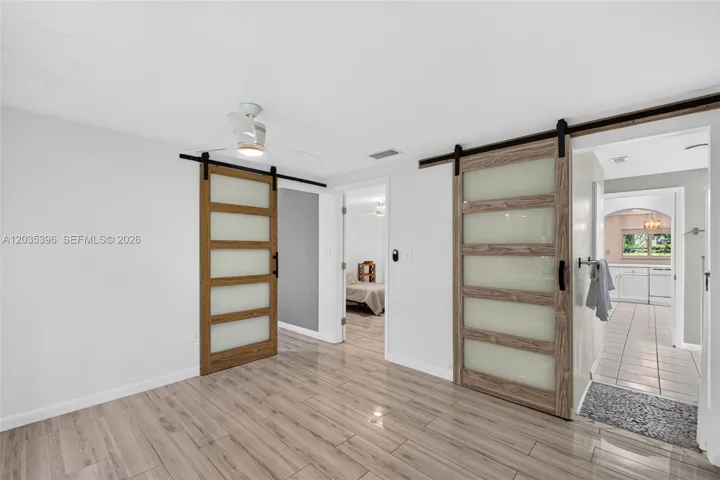 Second bedroom in Guest House with closet. One barn door provides access to a bonus room / office / 3rd bedroom in the guest house. The other leads to the bathroom and toward the kitchen. Middle door is toward first bedroom