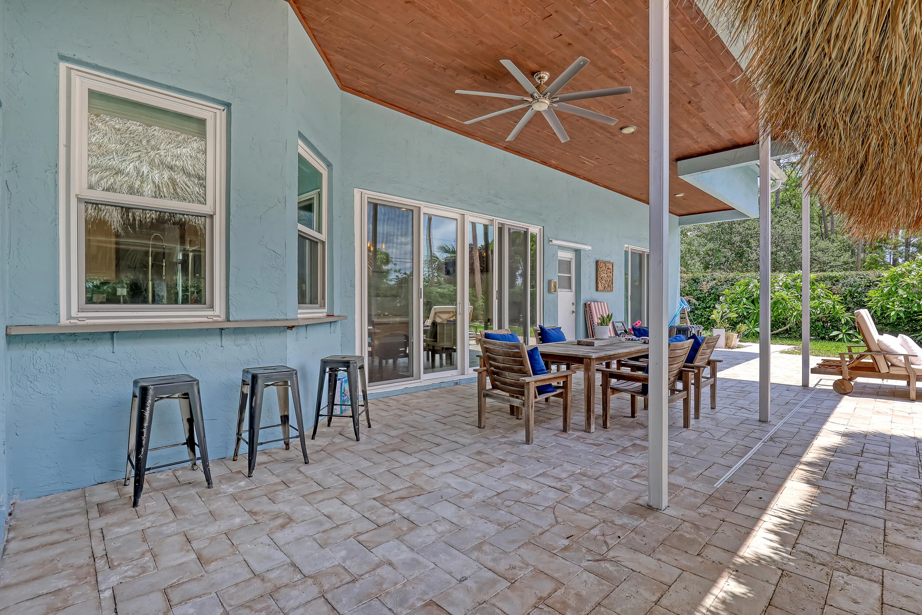 Expansive covered patio featuring a wood-finish ceiling, ceiling fan, and paver flooring