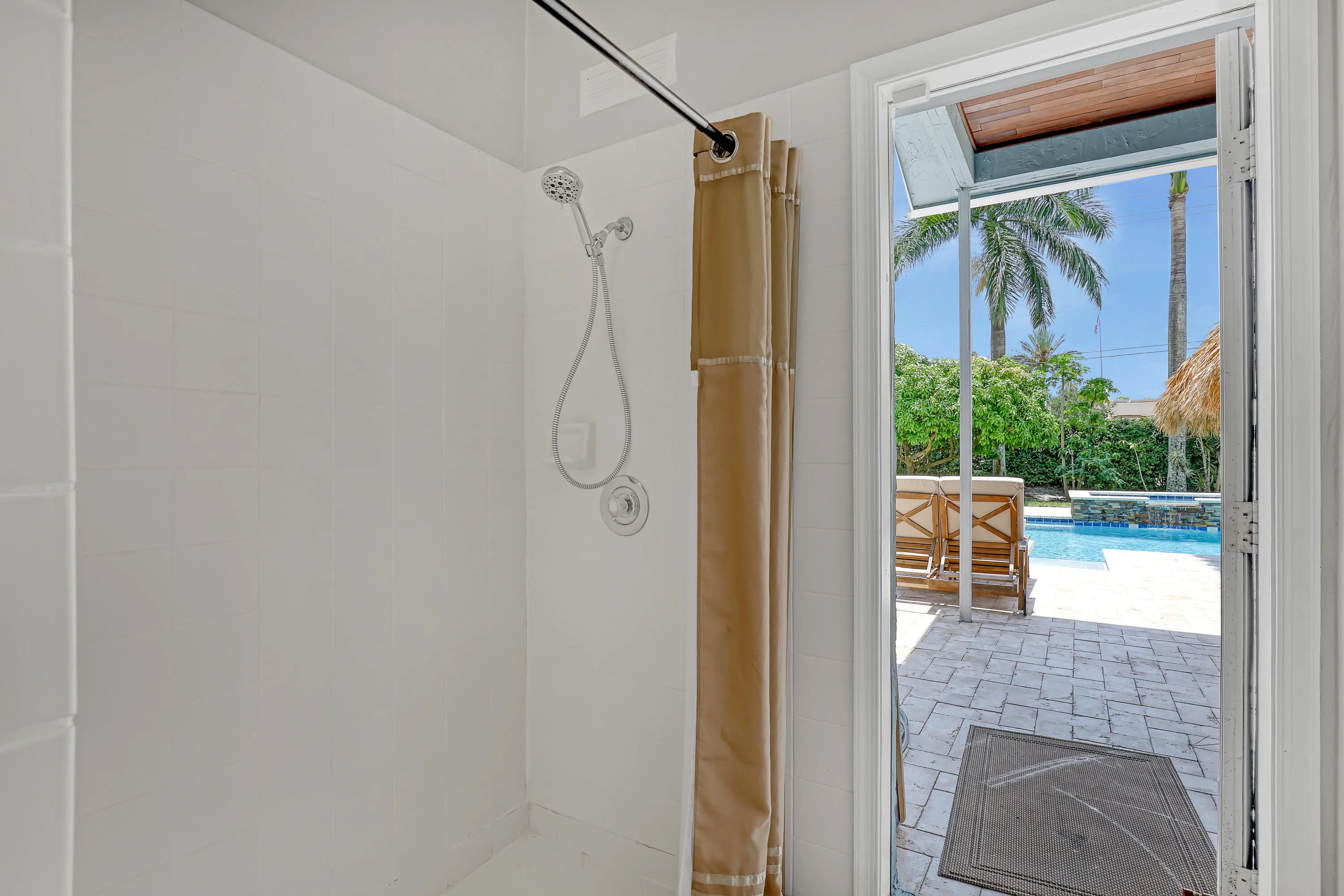 Shower with white tiled walls and chrome fixtures