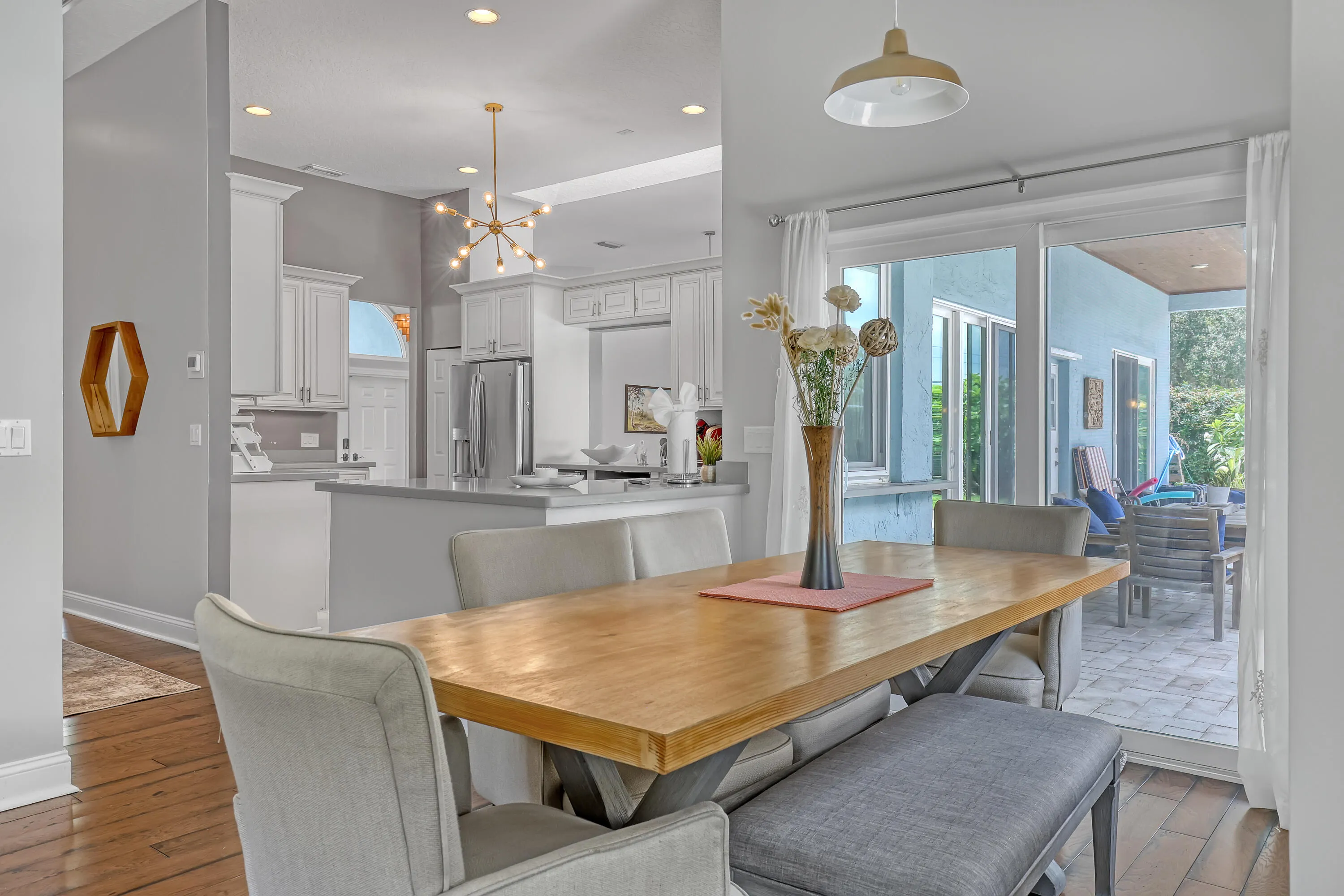 Breakfast area featuring wood-finish flooring, a contemporary chandelier, and direct access to an outdoor patio through sliding glass doors