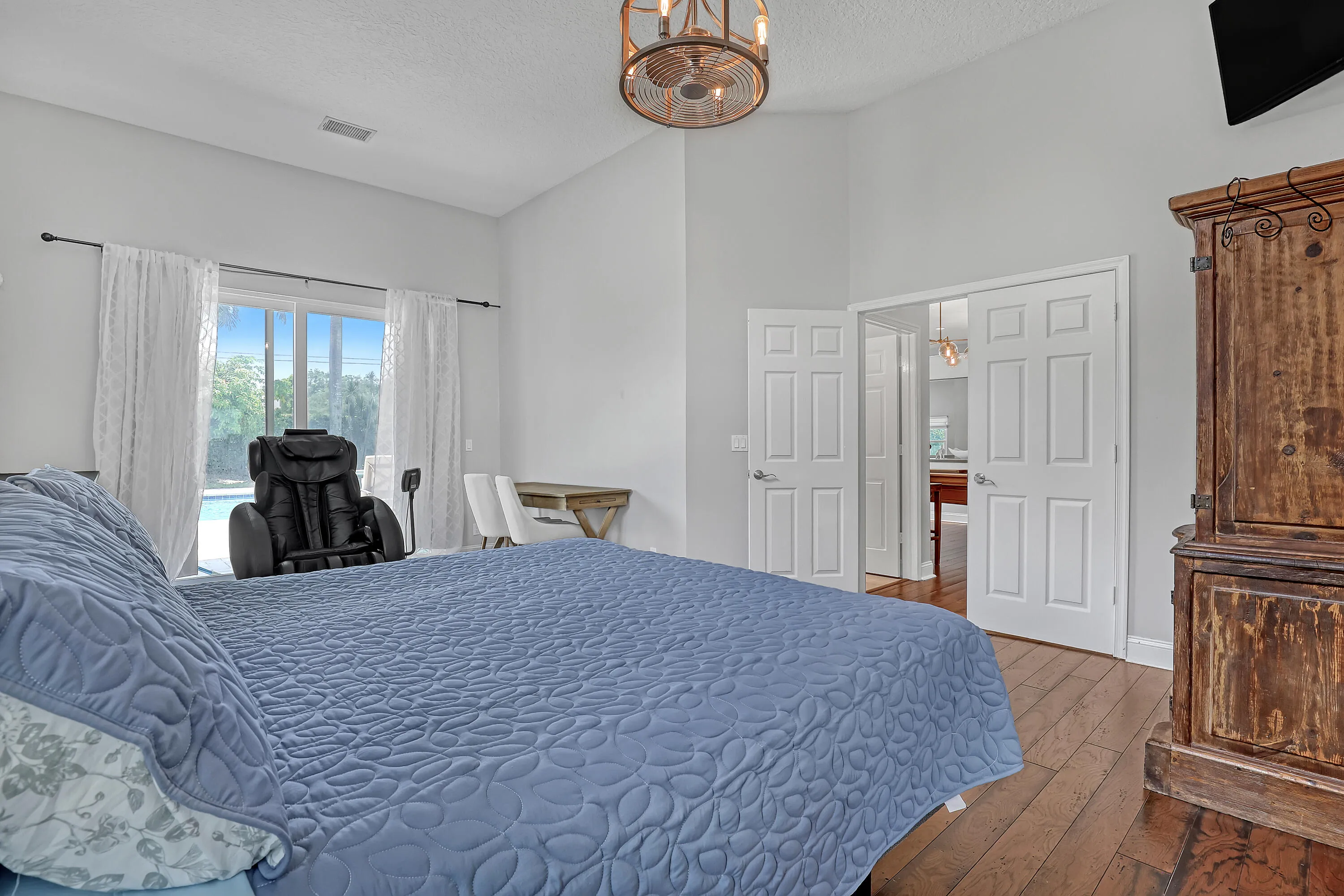 Vaulted ceiling bedroom with wood-finish flooring