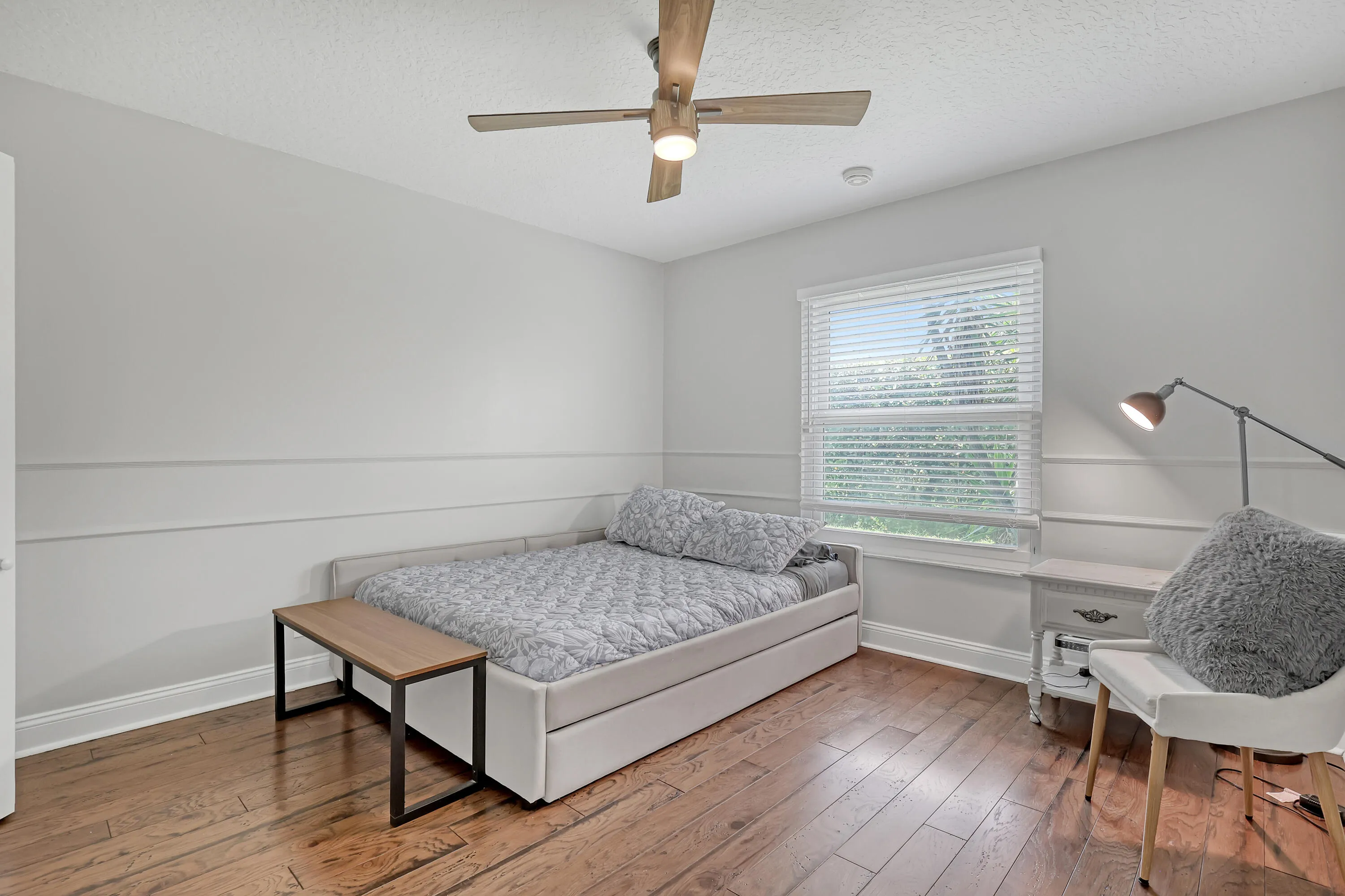Hardwood flooring complements a neutral color palette with wainscoting detailing