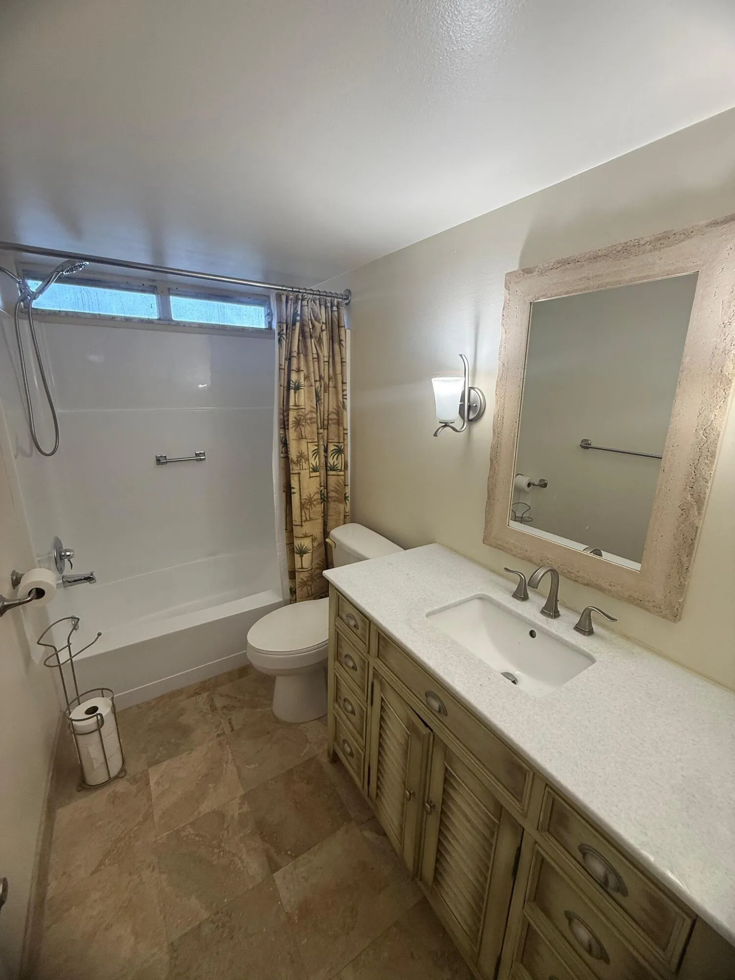 Bathroom featuring a vanity with a light-colored countertop and an integrated sink, a large framed mirror, a tub/shower combination, and tile flooring