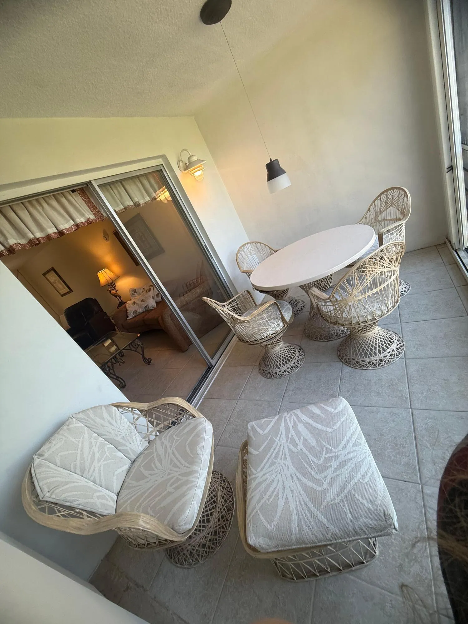 Screened patio featuring tile flooring and a wall-mounted light fixture