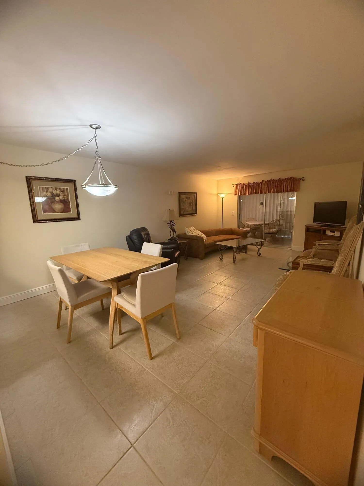 Open-concept living space featuring neutral tone tile flooring throughout