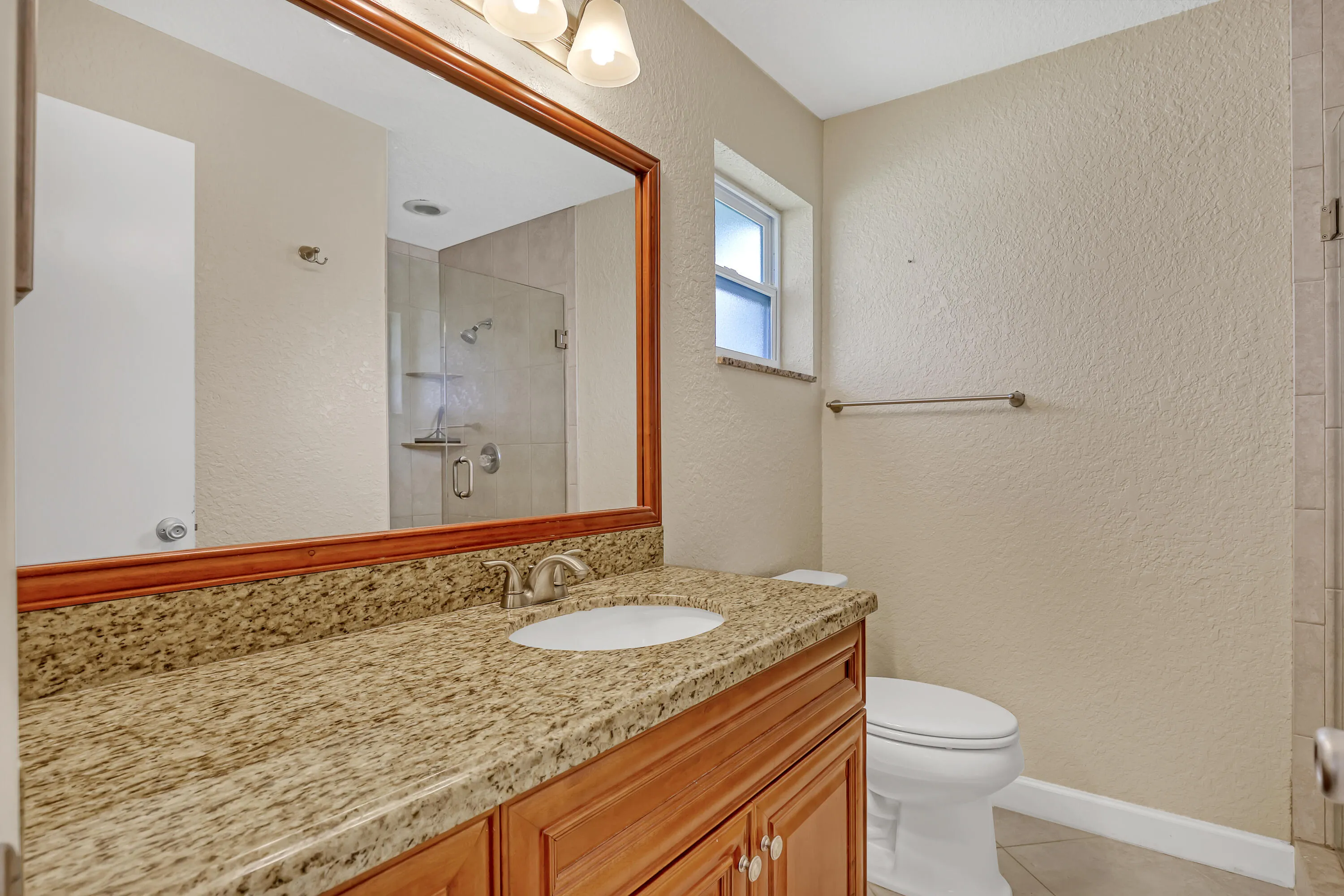 Beautifully updated master bath with glass enclosed shower. Vanity replaced with granite counter. New electrical fixture. Shower stall all retiled.