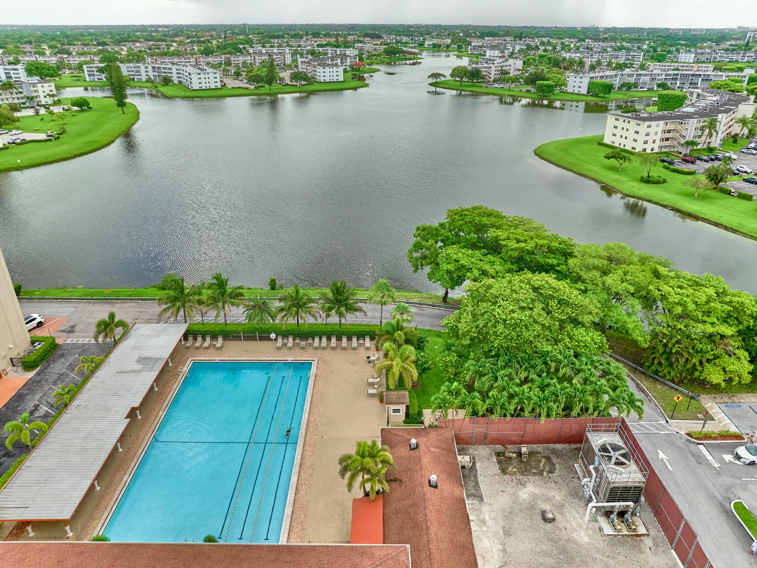 Expansive water features and lush landscaping define the surrounding environment, complemented by a large outdoor swimming pool with dedicated lap lanes