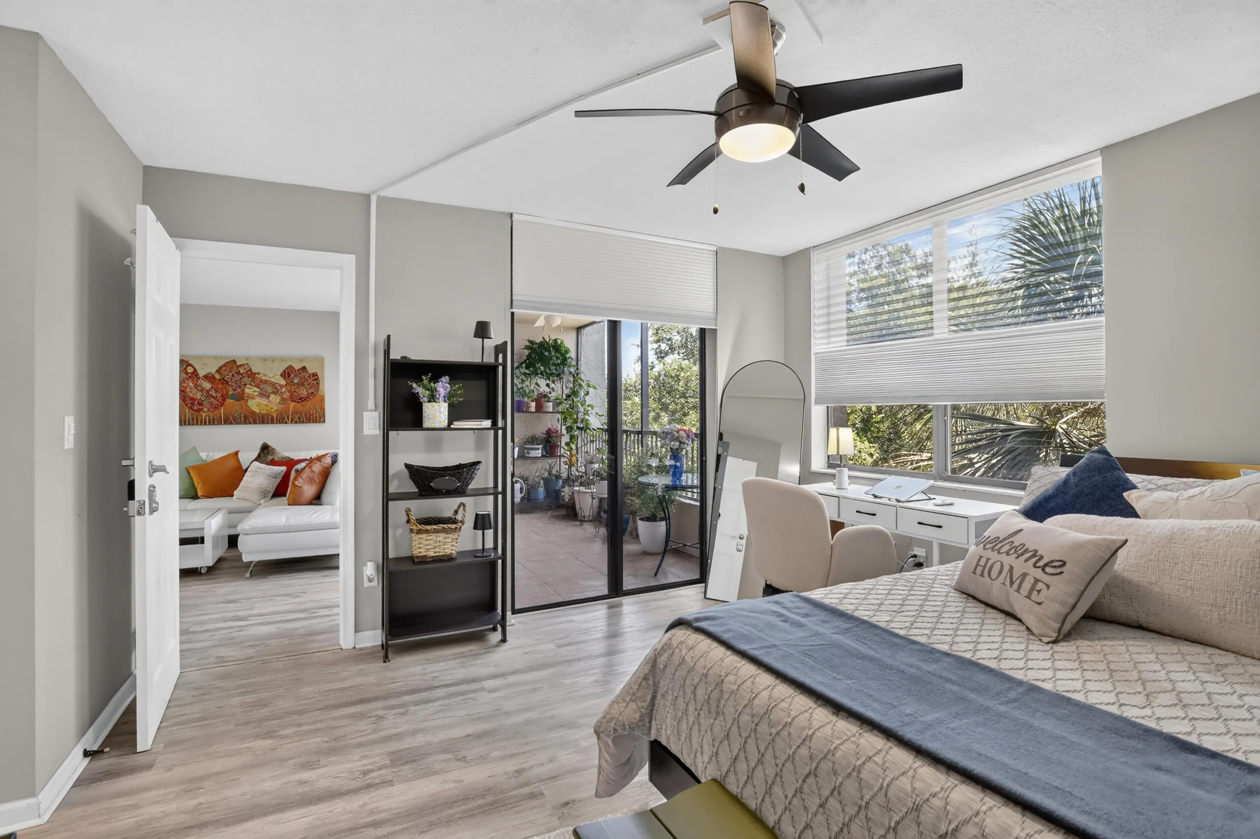 Spacious room featuring wood-finish flooring, a contemporary ceiling fan, and a wide window with blinds