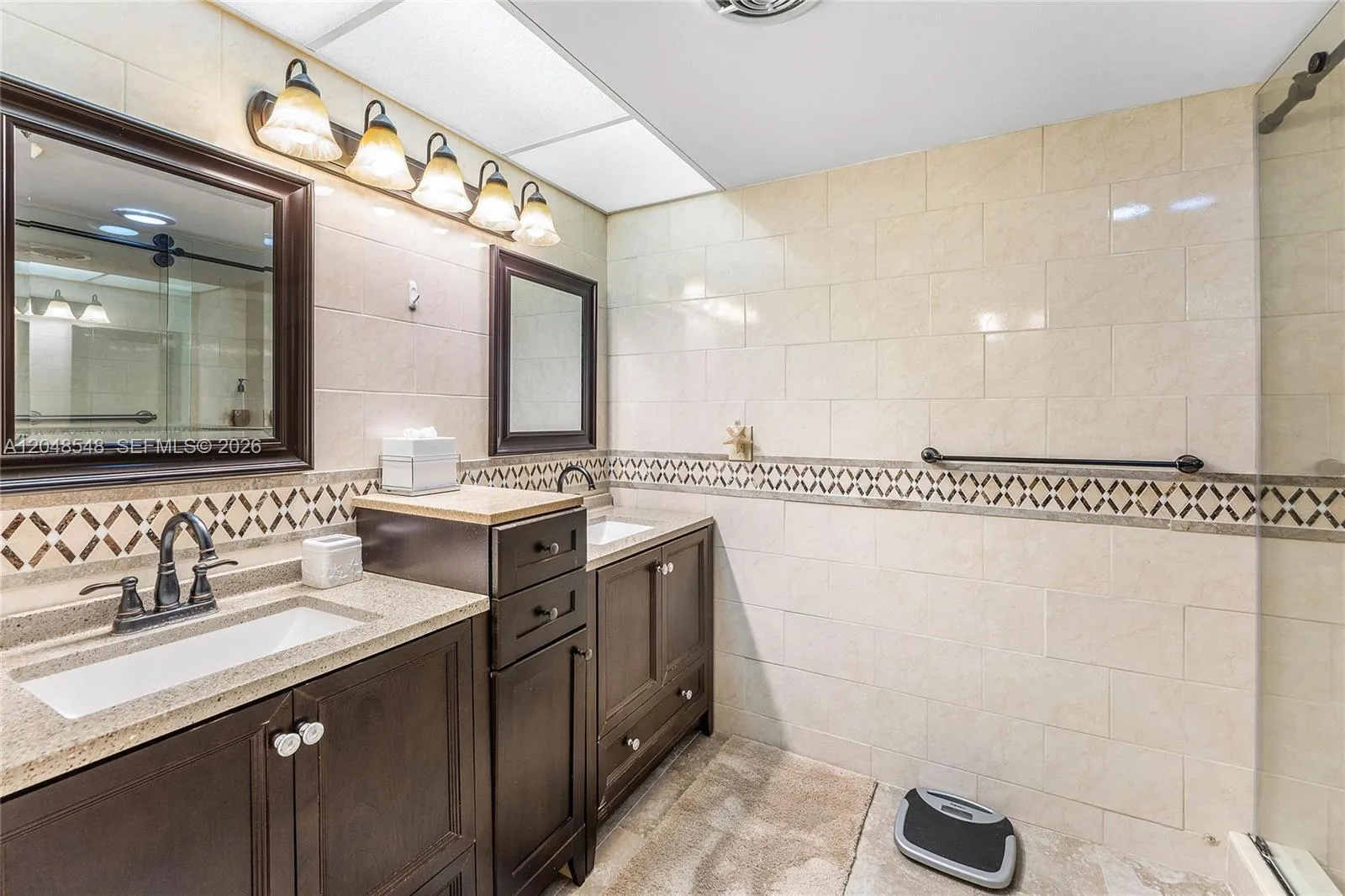 Updated primary bath with dual sinks, glass enclosed shower