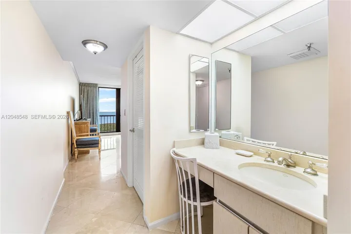 Dressing area with sink and marble top in primary suite