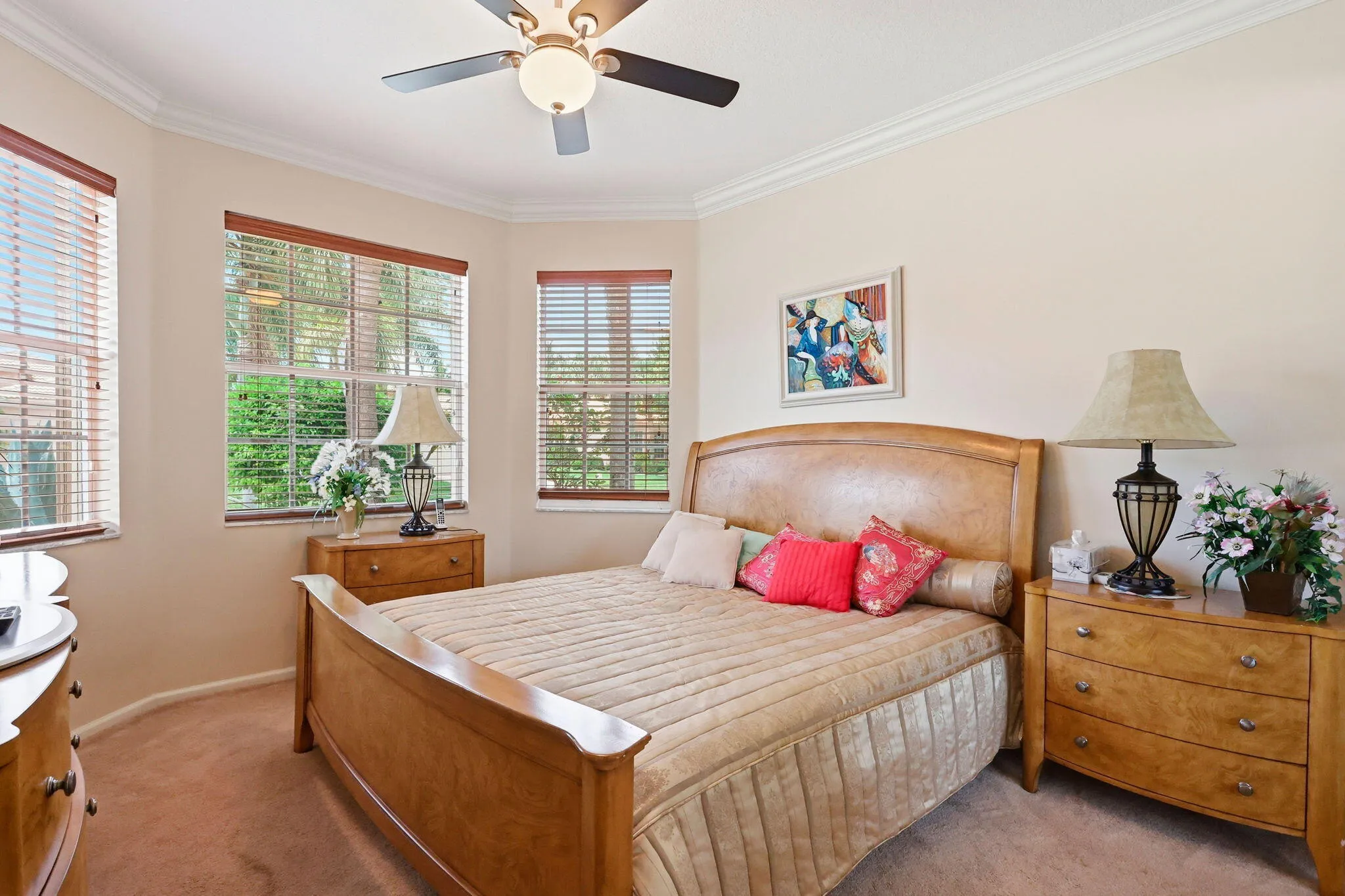 Bay window with three large windows, crown molding, and a ceiling fan