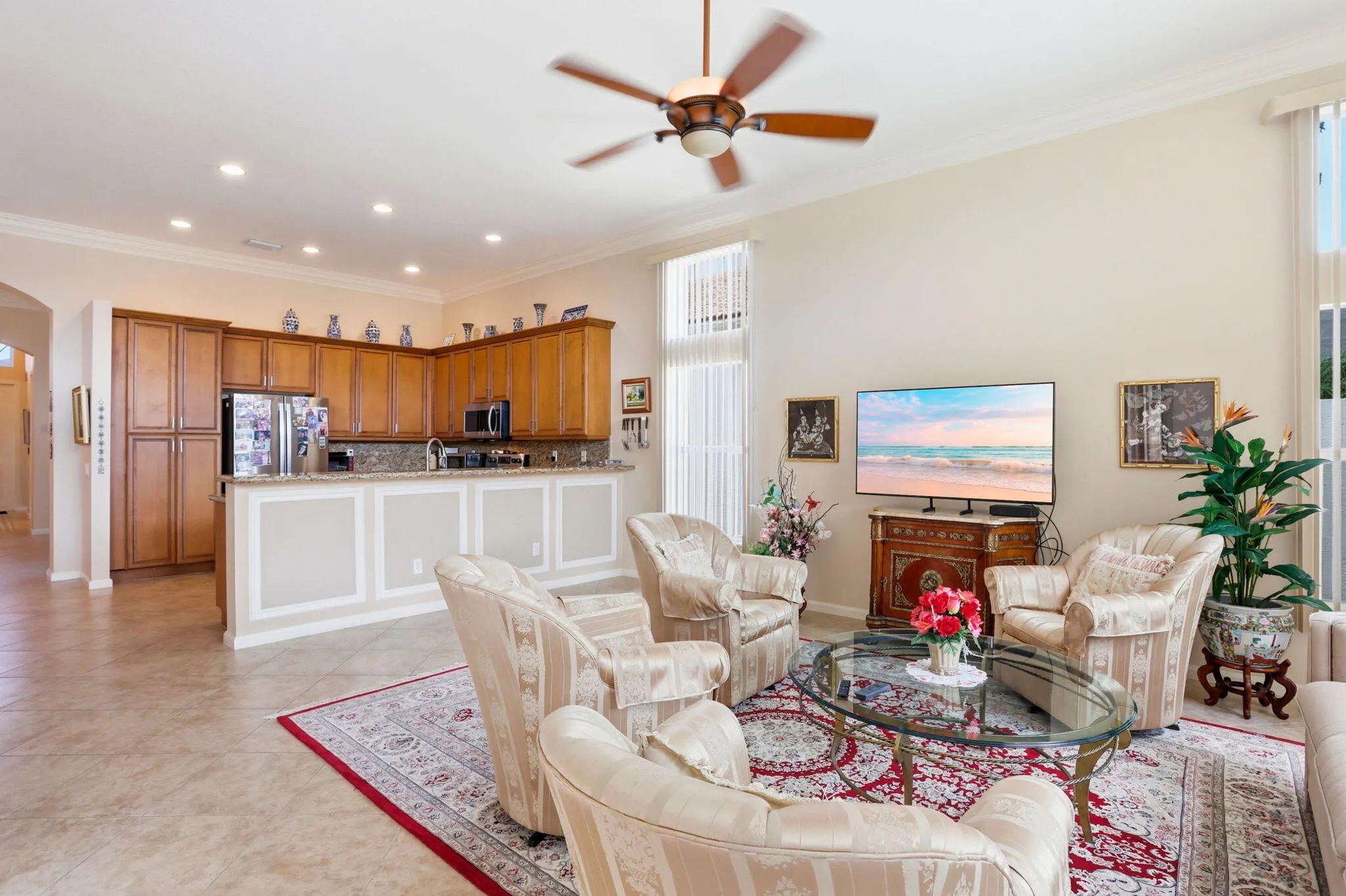 Open concept living space featuring a high ceiling with crown molding, recessed lighting, and tile flooring