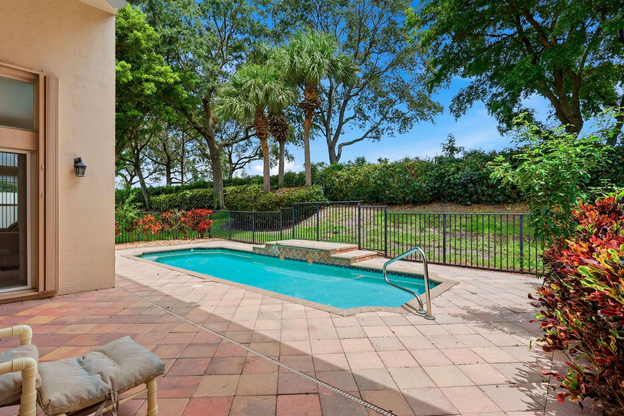 Outdoor living space featuring a rectangular swimming pool with integrated spa, surrounded by a paver patio