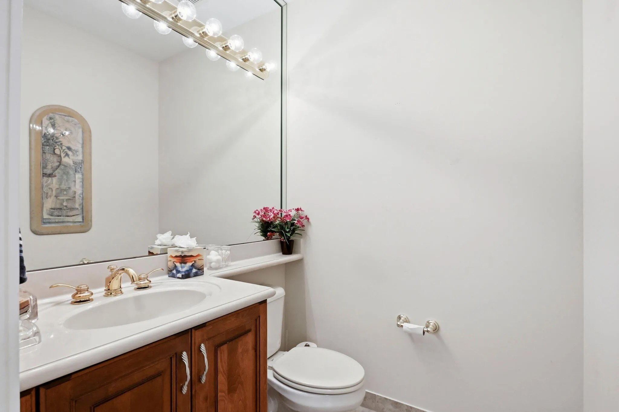 Bathroom vanity featuring wood cabinetry, an integrated sink, and gold-tone fixtures