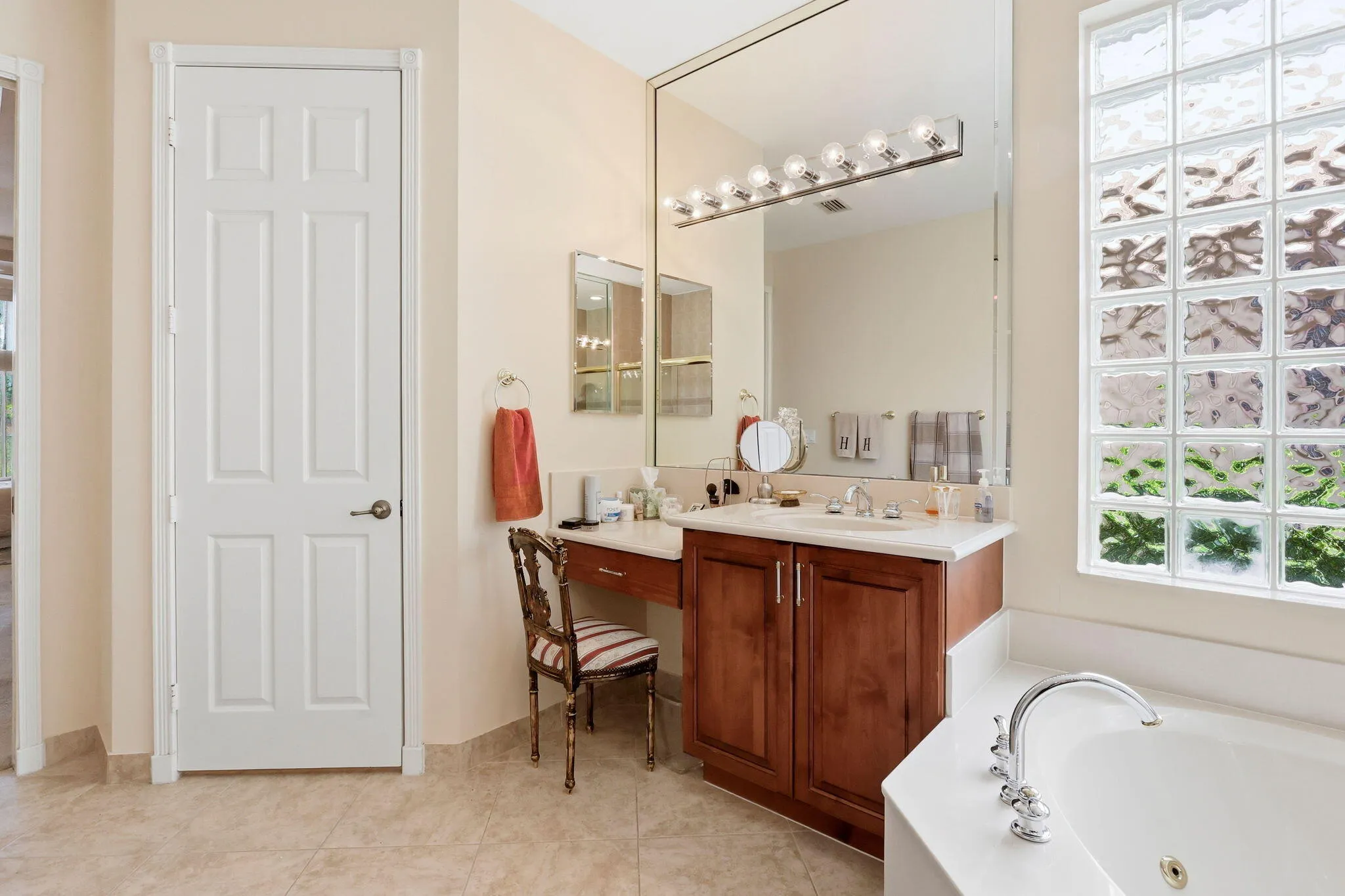 Bathroom featuring a vanity with a wood-finish cabinet, integrated sink, and white countertop