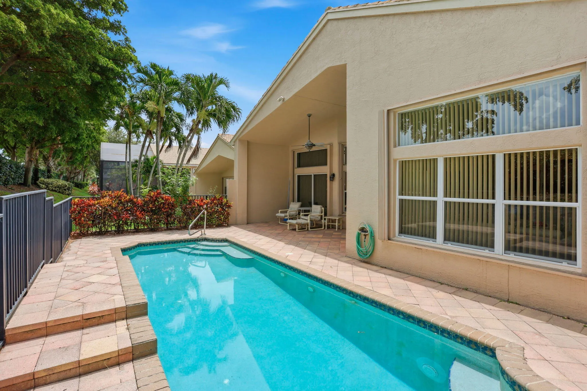 Rectangular swimming pool with integrated steps, surrounded by paver decking