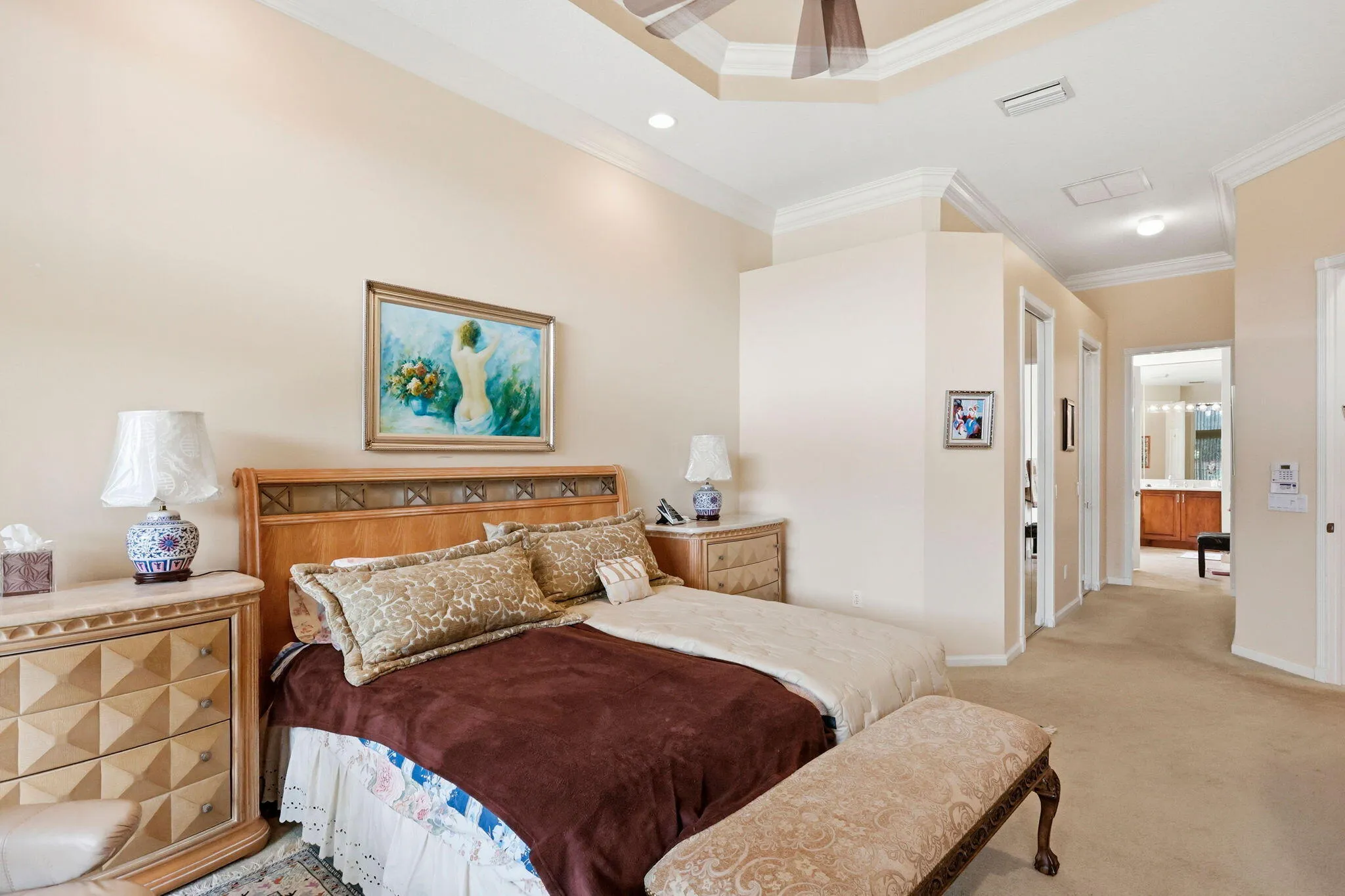 Bedroom featuring a tray ceiling with crown molding, light-toned walls, and carpeting