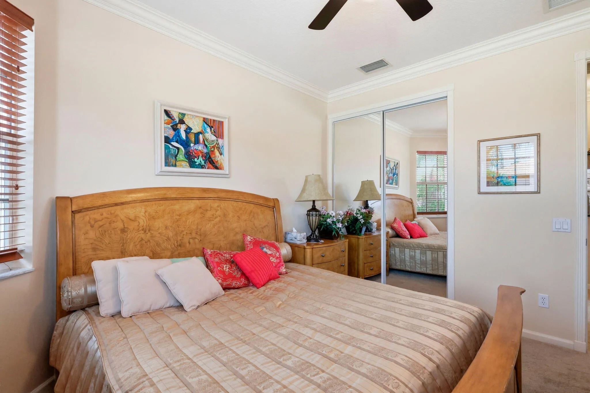 Bedroom featuring crown molding, a ceiling fan, and mirrored closet doors