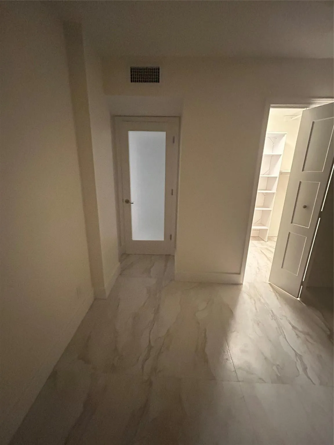 New wood base boards throughout the room and new paint. The walk-in closet new bifold door opens to the left side. New frosted glass door separates the room from the hallway