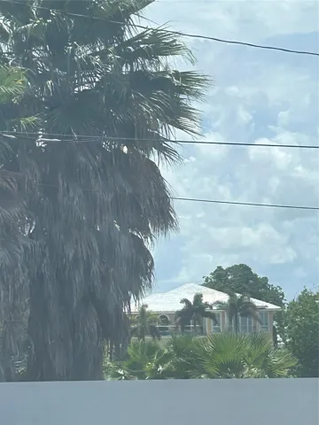 Across the Intracoastal waterway landscaped homes are visible. Boats moving on the waterway can be seen from the windows inside this condominum unit.