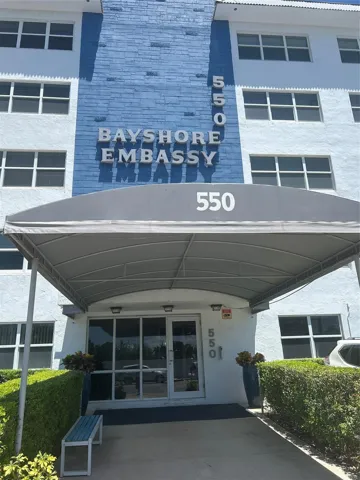 building entrance has canopy on walkway to front door. Landscape surrounds the sides and parking is assigned. Guest spaces are marked in yellow.