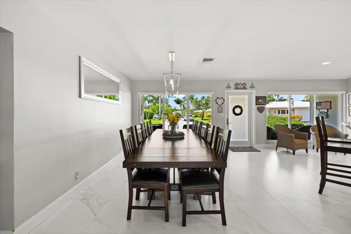Open-concept living space featuring expansive white tile flooring and light-toned walls