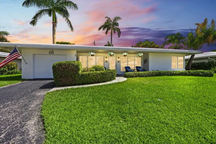 Single-story residence featuring a white exterior and a dark asphalt driveway