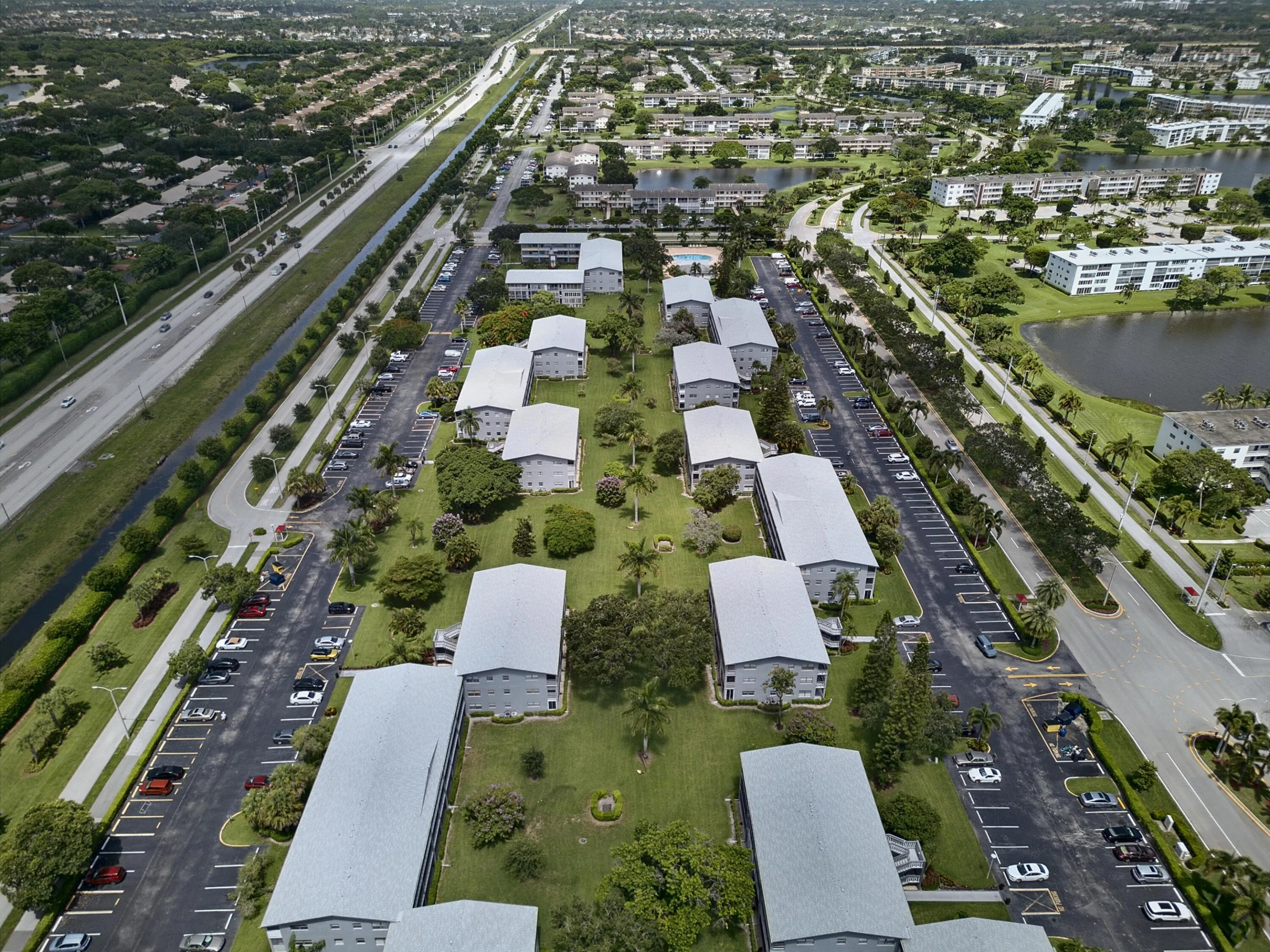 Aerial perspective showcasing a community of multi-story residential buildings with abundant surface parking